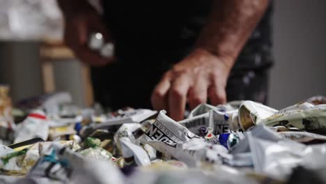 Artist-sifting-through-paints-on-table