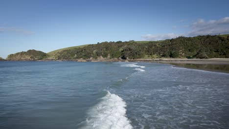 Waves-Crashing-Towards-White-Sandy-Beach-Of-Tawharanui-Regional-Park---Aerial-shot