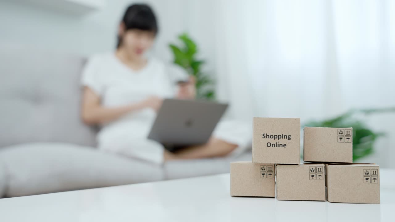 Asian women are paying online by credit card at home. Women are shopping for the things they like on their computers. Concept of ​​online shopping .