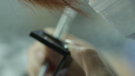 female factory worker doing a quality inspection of a textile sample using magnifying glass and tweezers in a textile factory in china