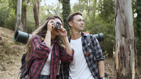 hikers with photo camera taking pictures of forest landscape