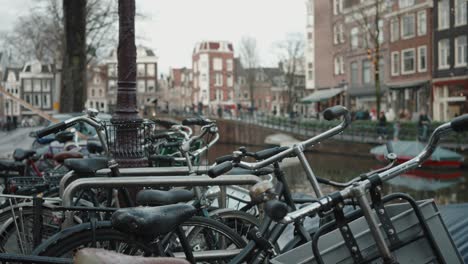 amsterdam canal view with bicycles lined up, historic houses, and moored boats