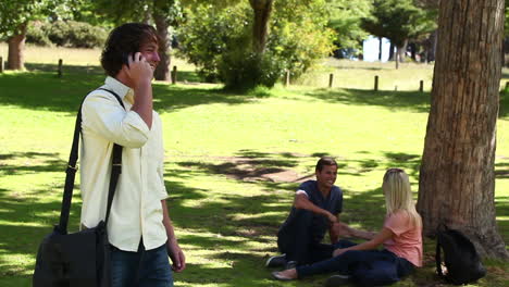 Man-laughing-as-he-talks-on-a-phone-before-hanging-up-and-looking-at-the-camera