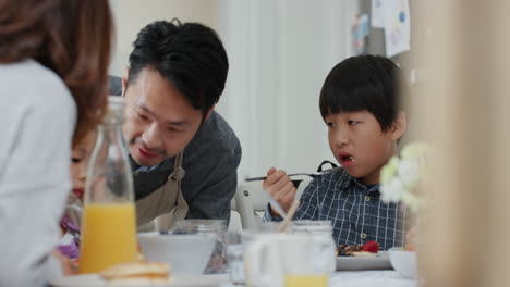 Familia-Asiática-Feliz-Comiendo-Panqueques-Para-El-Desayuno,-Niños-Disfrutando-De-Una-Comida-Casera-Saludable-Con-Sus-Padres-El-Fin-De-Semana-Por-La-Mañana-En-La-Cocina,-Imágenes-De-4k