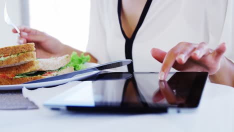 Mujer-Almorzando-Y-Usando-Tableta