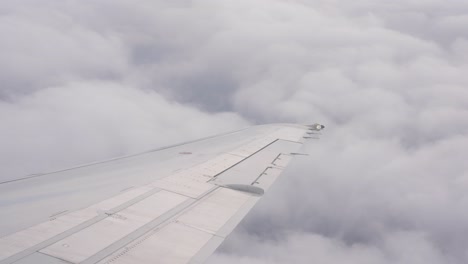 Steady-shot-of-airplane-wing-flying-above-the-clouds-in-the-afternoon