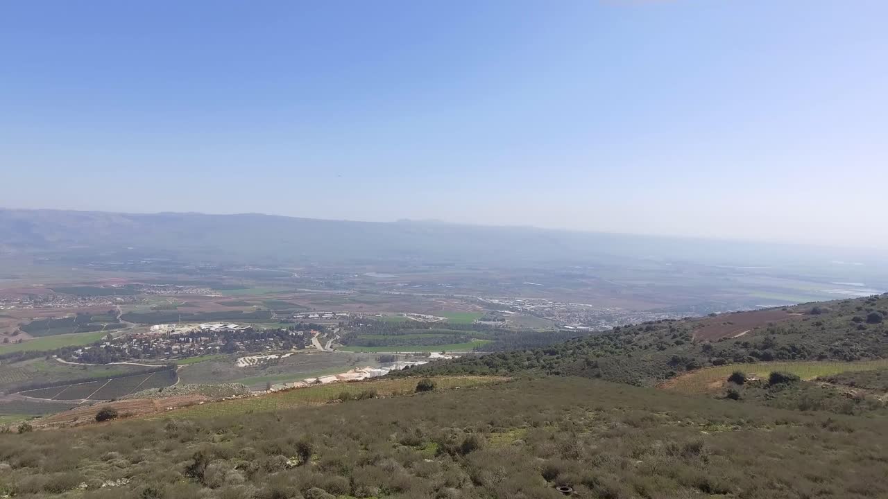 enorme valle con un pueblo al fondo expuesto y la montaña hermon al fondo