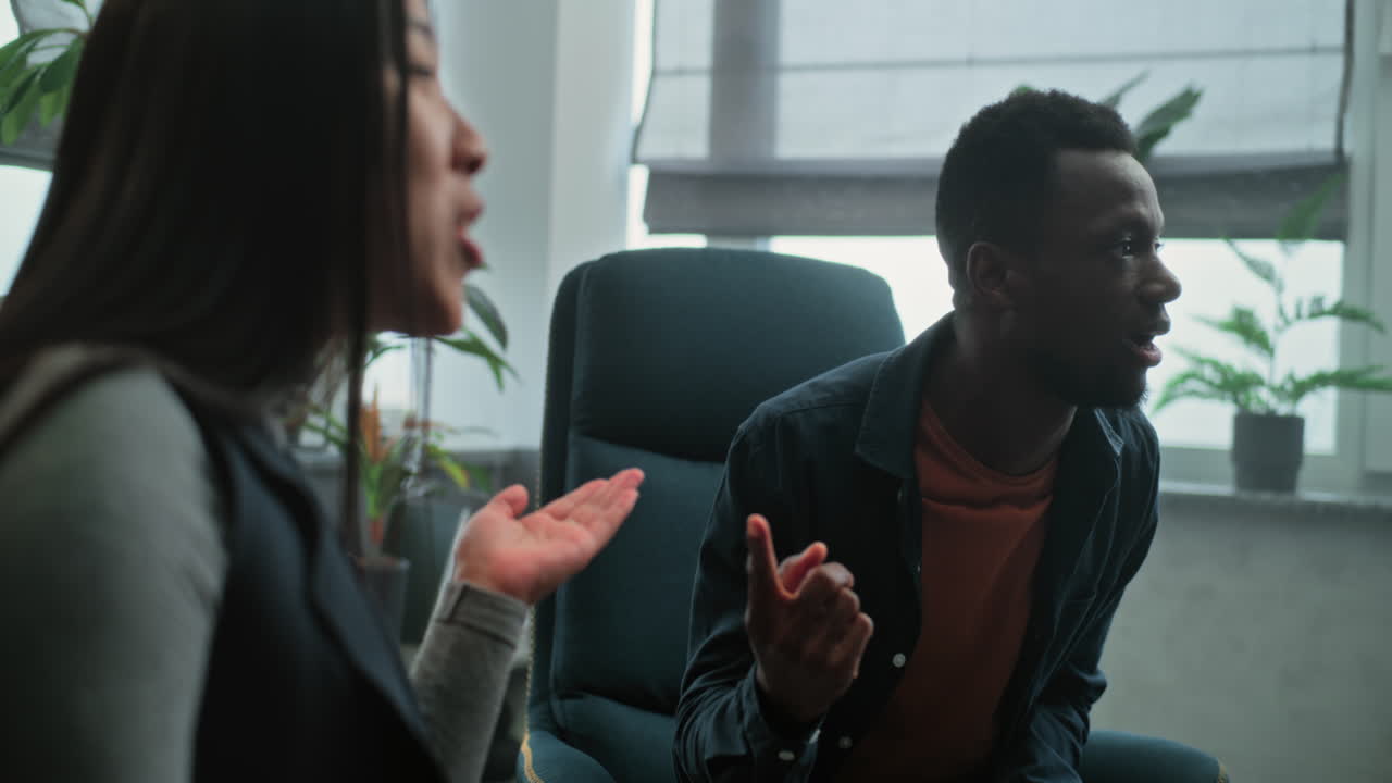 Multiethnic Couple Having Conflict on Couples Therapy with Family Psychotherapist Aggressive African American Boyfriend Loses Temper Starts Fight Shouts at his Girlfriend Asian Woman Yells back Multiethnic Couple Having Conflict on Couples Therapy with Family Psychotherapist