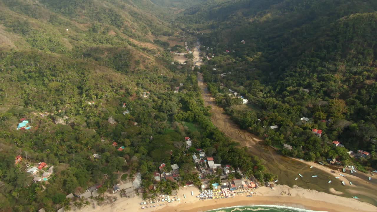 río entre las verdes montañas con la ciudad costera de yelapa y barcos en el mar en jalisco, méxico