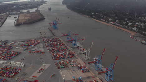 Large-commercial-industrial-cargo-port-with-colorful-cargo-containers-by-the-river-in-Hamburg,-Germany