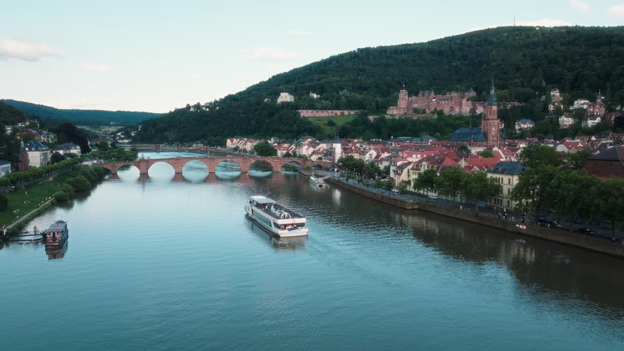 Battello da crociera che naviga sul fiume Neckar vicino al famoso ponte ad arco a Heidelberg.