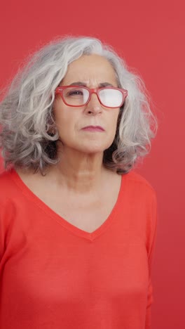 Senior woman struggling to see through red glasses