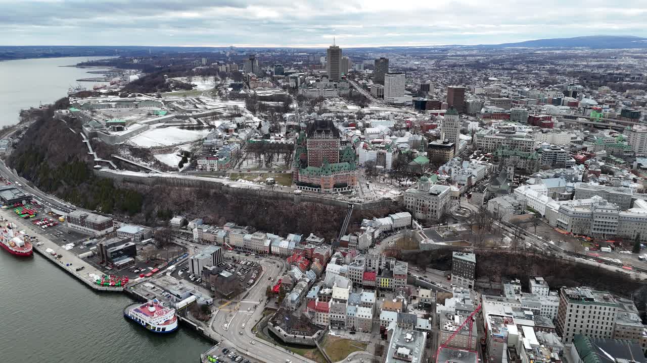 Jelajahi pesona bersejarah Kota Quebec dengan pemandangan udara yang menakjubkan, menampilkan perpaduan arsitektur lama dan baru, atap-atap bersalju, dan pemandangan kota yang semarak di bawah langit berawan, Kanada
