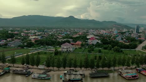drone-view-of-river-boats-and-the-buildings-in-Kampot-Province,-Cambodia