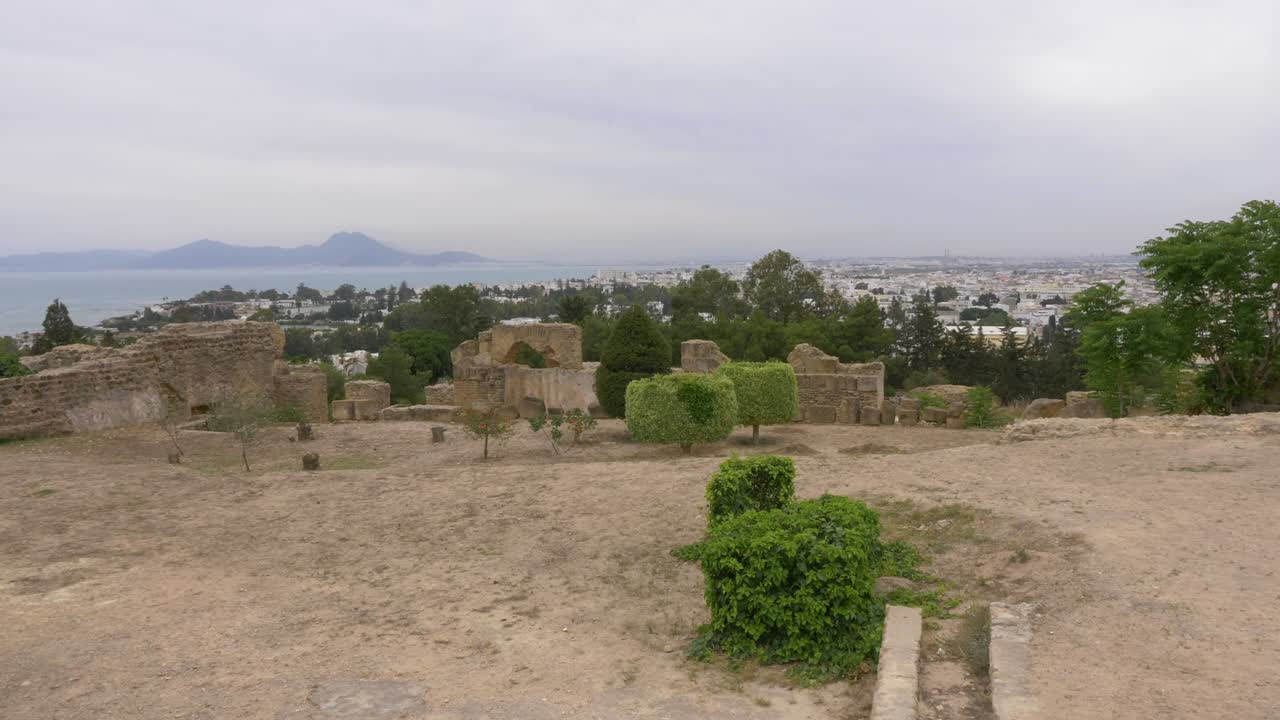 paisaje con antiguas ruinas de cartago, árbol, ciudad, mar y montaña en túnez.