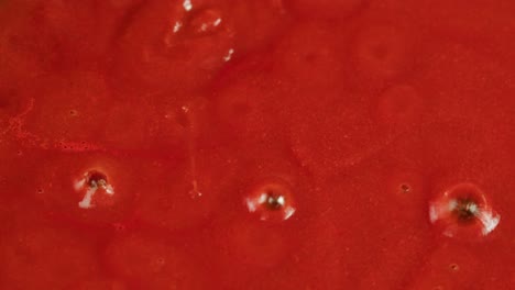 Boiling tomato sauce on a frying pan close-up. Cooking tomato sauce or soup. Traditional Italian Mexican Asian dish. High quality studio shot for cafe, restaurant close up. Marinara sauce for Italian pasta