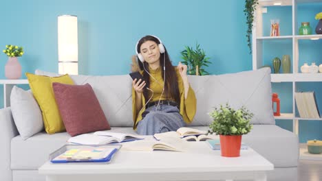 Young-girl-listens-to-music-with-headphones-at-home.