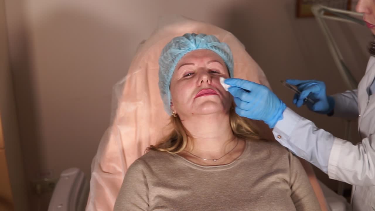 Woman receiving facial filler injection procedure