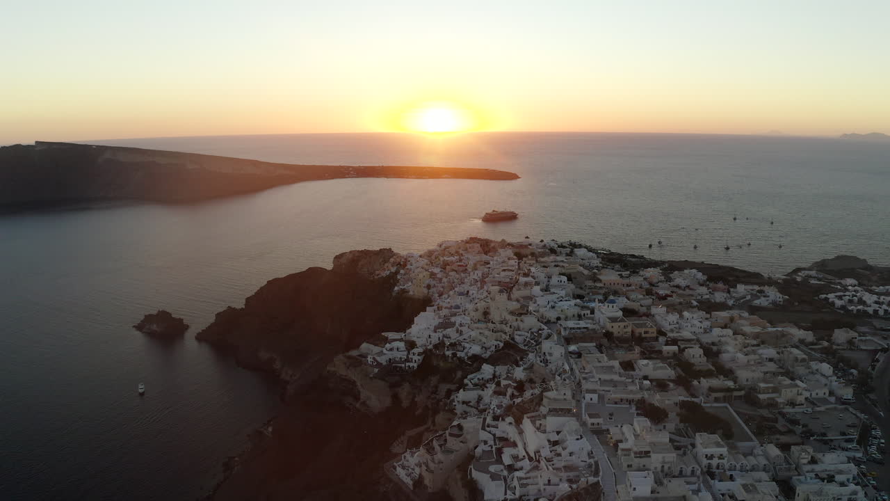 oia santorini island sunset drone shot con vistas a edificios blancos y al mar, grecia en 4k