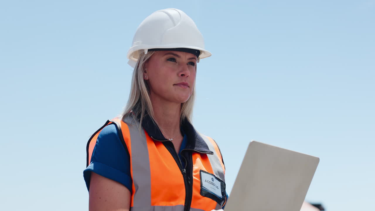 Female Engineer in Hard Hat and Safety Vest Inspecting Site