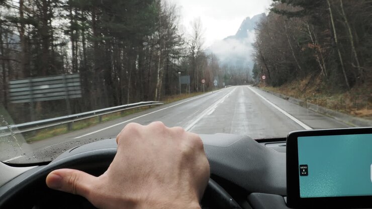 Guidare su una strada di montagna in una giornata piovosa