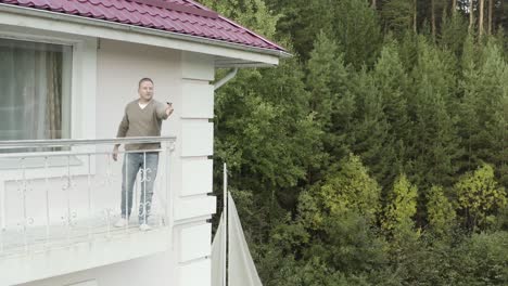 man on balcony looking at forest