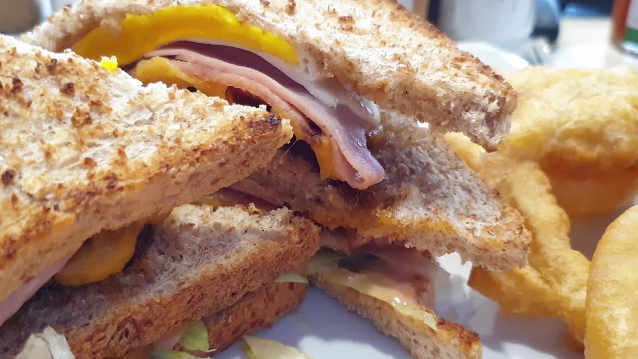 Delicious layered dagwood sandwich with pure beef patties and bacon, served with baked potato fries and rocket leaves.