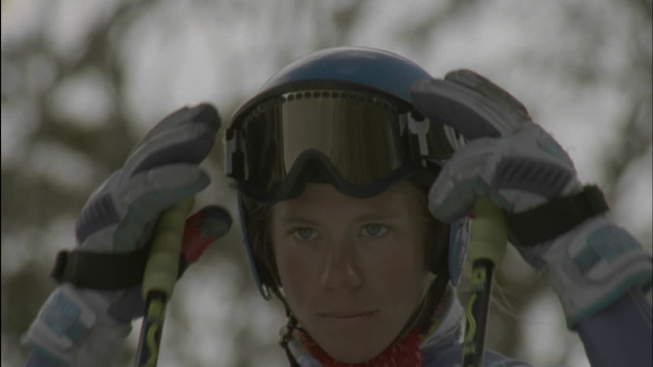 스키어가 슬로프를 이륙하기 전에 고글을 착용합니다.