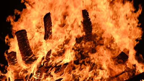 big bonfire burns at night in slow motion on a black background on nature