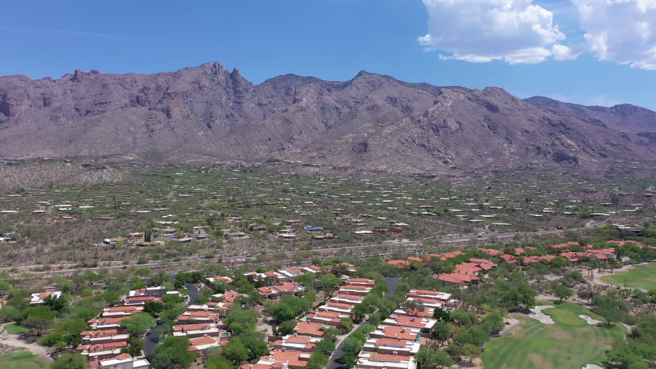 avance aéreo sobre la subdivisión de bienes raíces en catalina foothills, montañas rocosas en el fondo, tucson