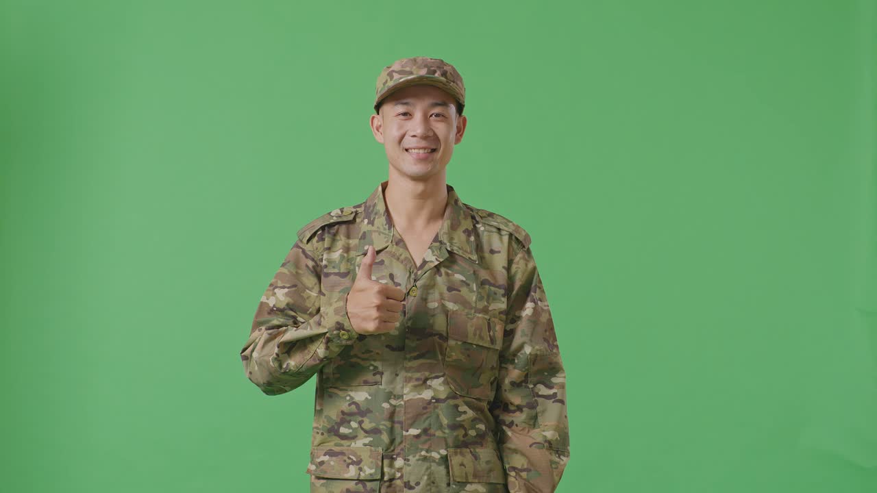위장 유니폼을 입은 미소 짓는 군인이 엄지손가락을 들고