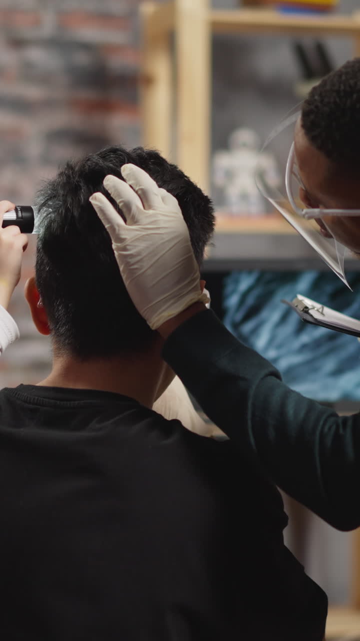 Little girl student with African-American biologist scans brunet man hair with digital probe to learn material texture via laptop in laboratory