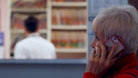 Side-view-of-caucasian-senior-patient-talking-on-mobile-phone-at-clinic-4k