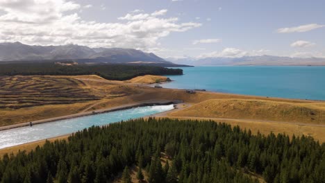 aerial approach towards water barrage at lake pukaki, nz in sunshine