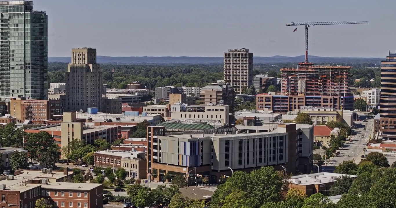 Durham North Carolina Aerial v18 telephoto low flyover across downtown high-rises, construction and the Warehouse District - Shot with Mavic 3 Pro Cine - Oct 1st 2023