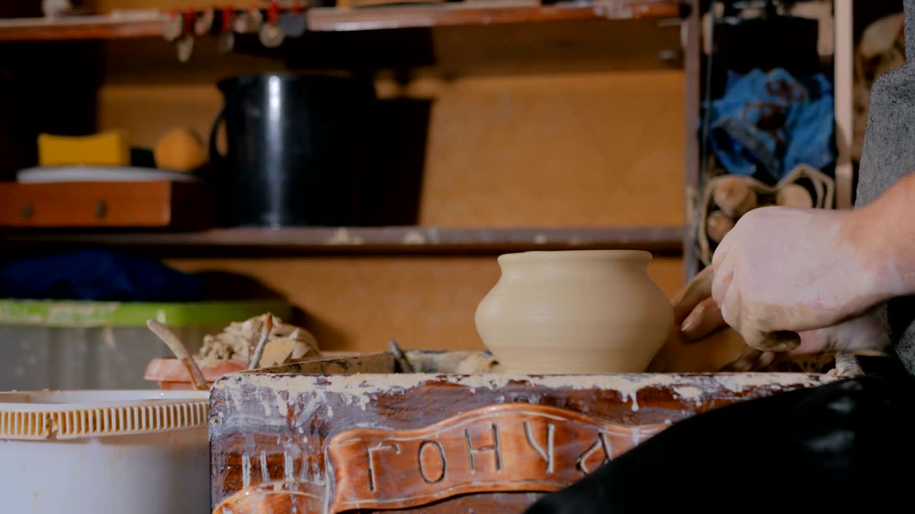 olla de tallado de alfarero profesional con herramienta especial en taller de alfarería
