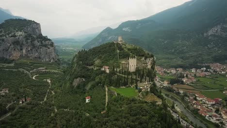 Drone-zoom-out-panorama-of-Castello-di-Arco-in-Trentino,-Italy