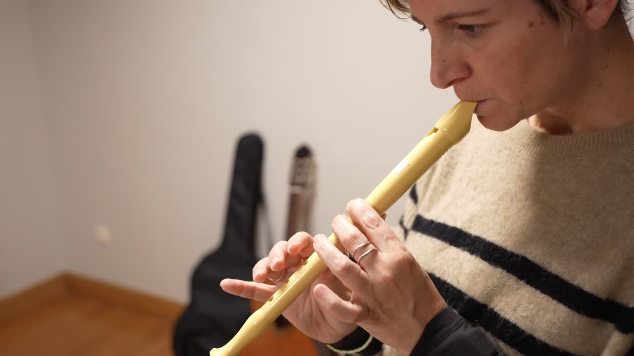 Close-up de mulher tocando um instrumento musical de flauta doce