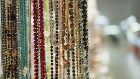 a close-up view of colorful beads hanging in an intricate display, the beads vary in color, size, and material