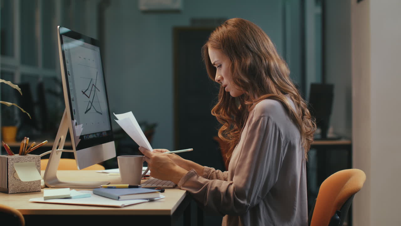 Focused business woman working with documents at night office