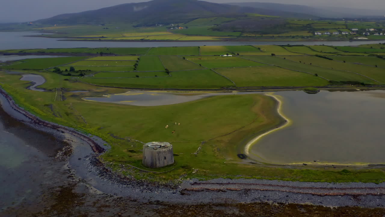 Smooth dynamic aerial of Aughinish Martello Tower, featuring the island, causeway, inlet, and surrounding County Clare landscape