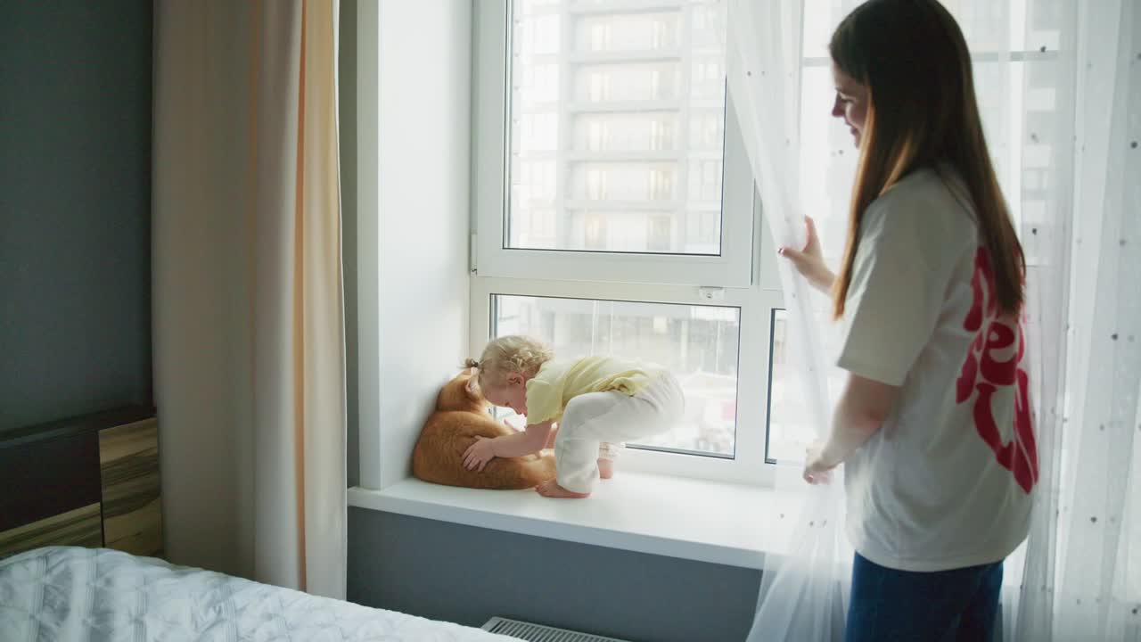 Sweet Toddler Hugging Pet Cat on Windowsill