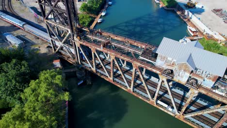 passenger train crosses over river on old bridge above view