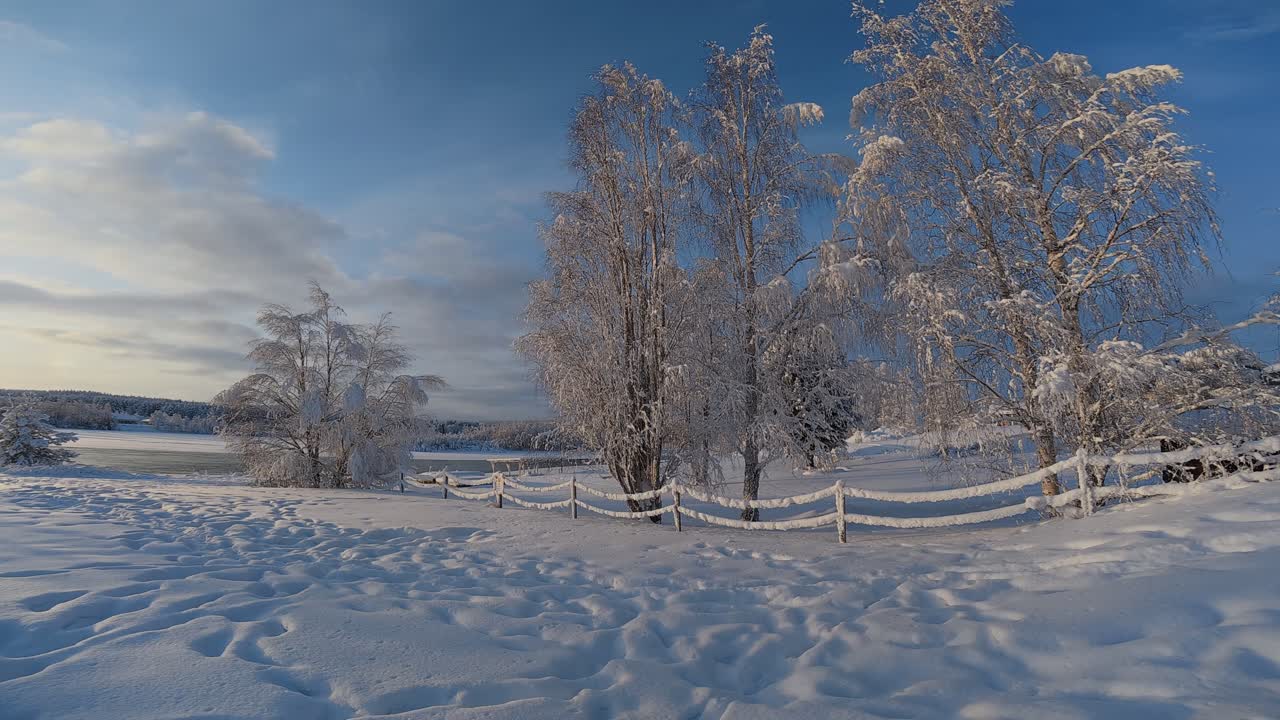 Arktyczne zimowe krajobrazy, ogrodzenie prowadzące do zamarzniętej rzeki, oblodzone drzewa, Rovaniemi, Finlandia, epickie lokalizacje.