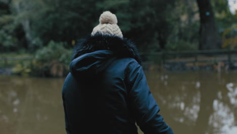 Mujer-Joven-Sentada-Sola-En-El-Parque-Disfrutando-De-Un-Estanque-De-Naturaleza-Tranquila-Adolescente-Solitaria-Sintiéndose-Deprimida-En-Un-Día-Frío-Y-Nublado