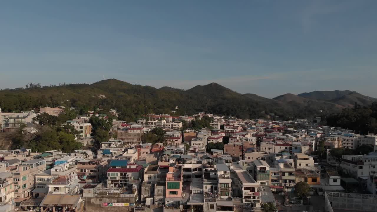 una reveladora vista aérea de un pueblo frente al mar ubicado en una bahía rodeada de árboles y naturaleza