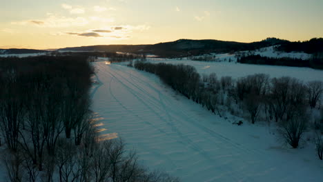 scenic winter aerial view over a snowy countryside at sunset