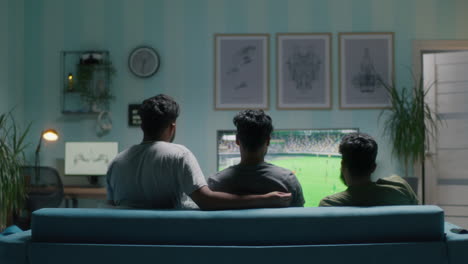 friends watching sports and celebrating a goal on tv at home