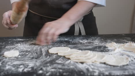 making meat dumpling with wooden rolling pin.