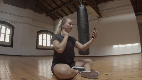 side view of female athlete taking her pulse rate in gym